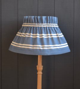 This is Dolly our on trend Blue Striped Gathered Scrunchie Lampshade. This a two piece set, the cover and the lampshade underneath. The cover slips on top easily, gathers beautifully and can be removed for hand washing.