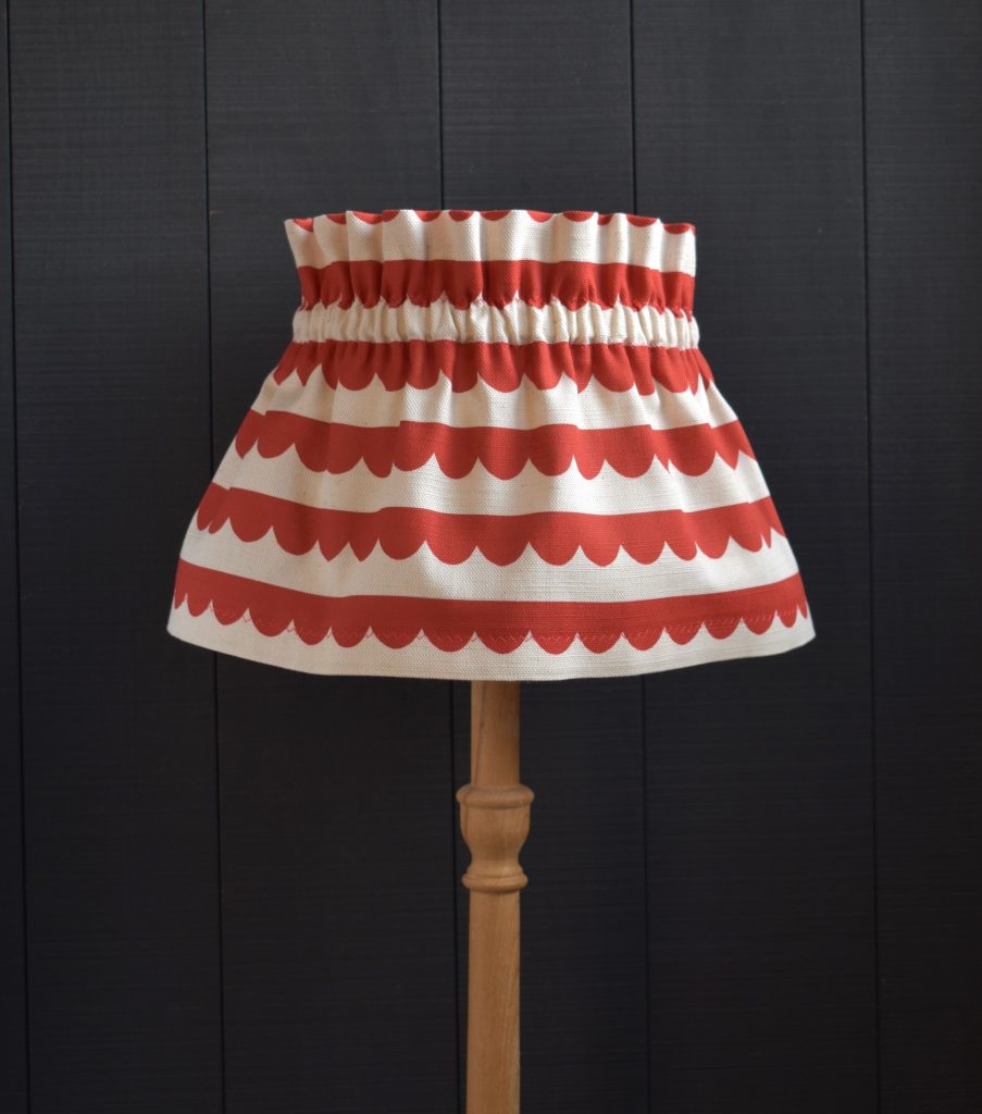 This is Dolly our on trend Cherry Red Scallop Scrunchie Lampshade. This a two piece set, the cover and the under lampshade. The cover slips on top easily, gathers beautifully and can be removed for hand washing.